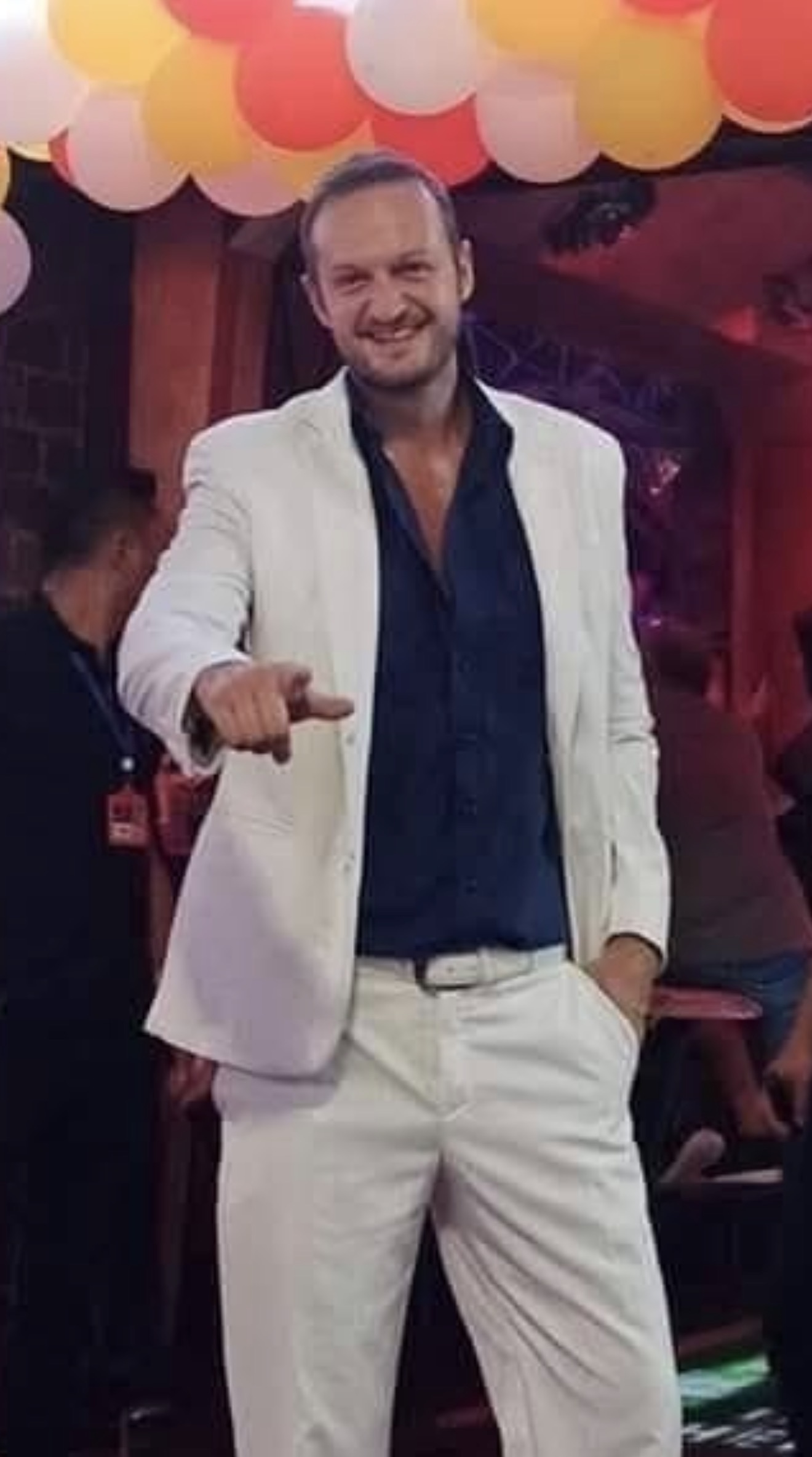 Yannis wearing a white suit in Pattaya.